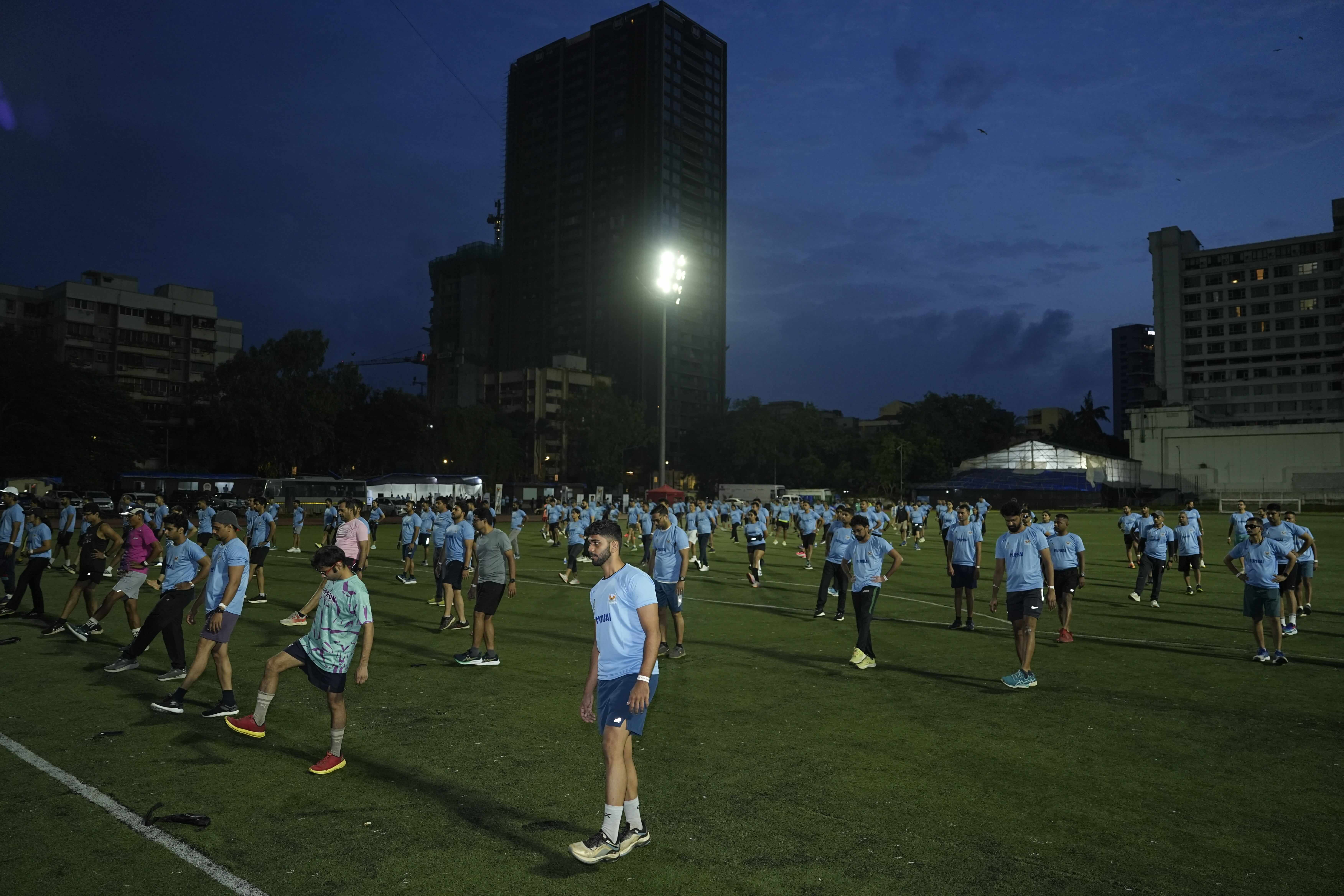 Runners warming up at dawn with dynamic stretches